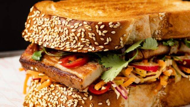 a sandwich on a plate with sesame seeds